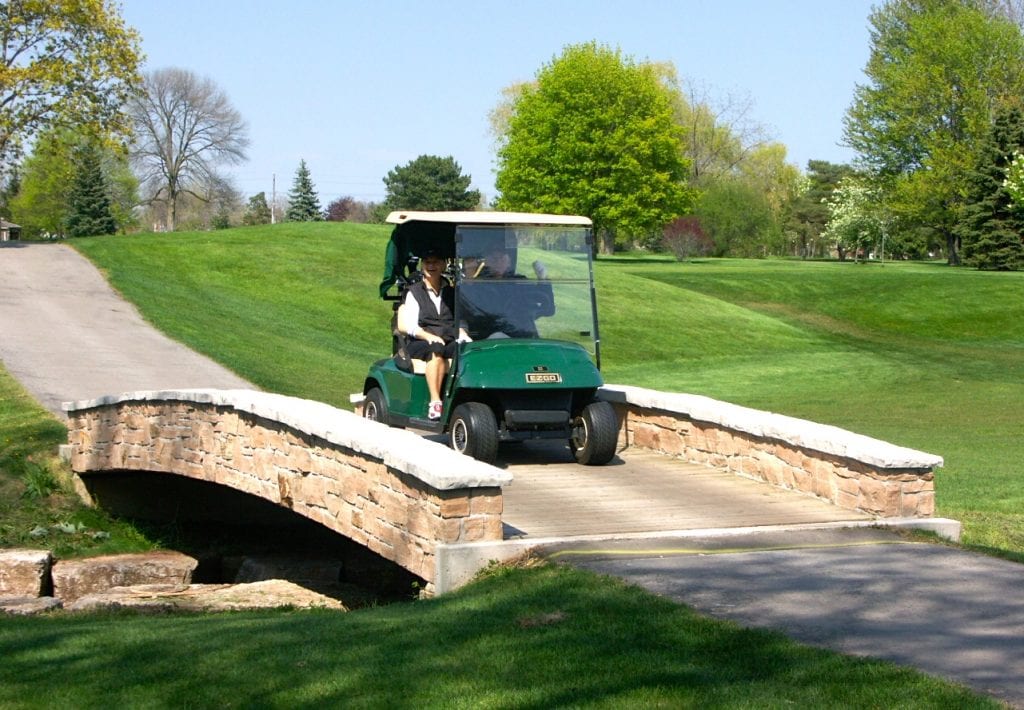 Golf cart crossing golf course bridge