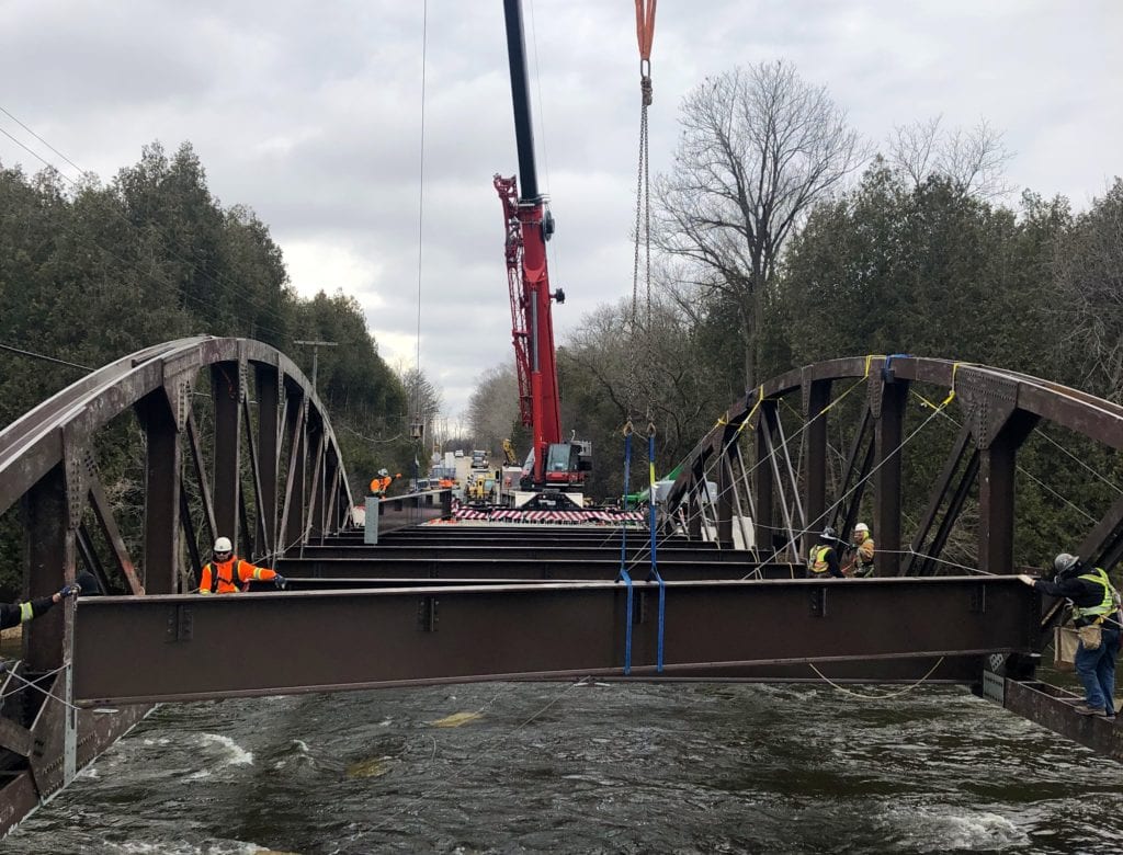 Crane lowers bridge cross beams into place