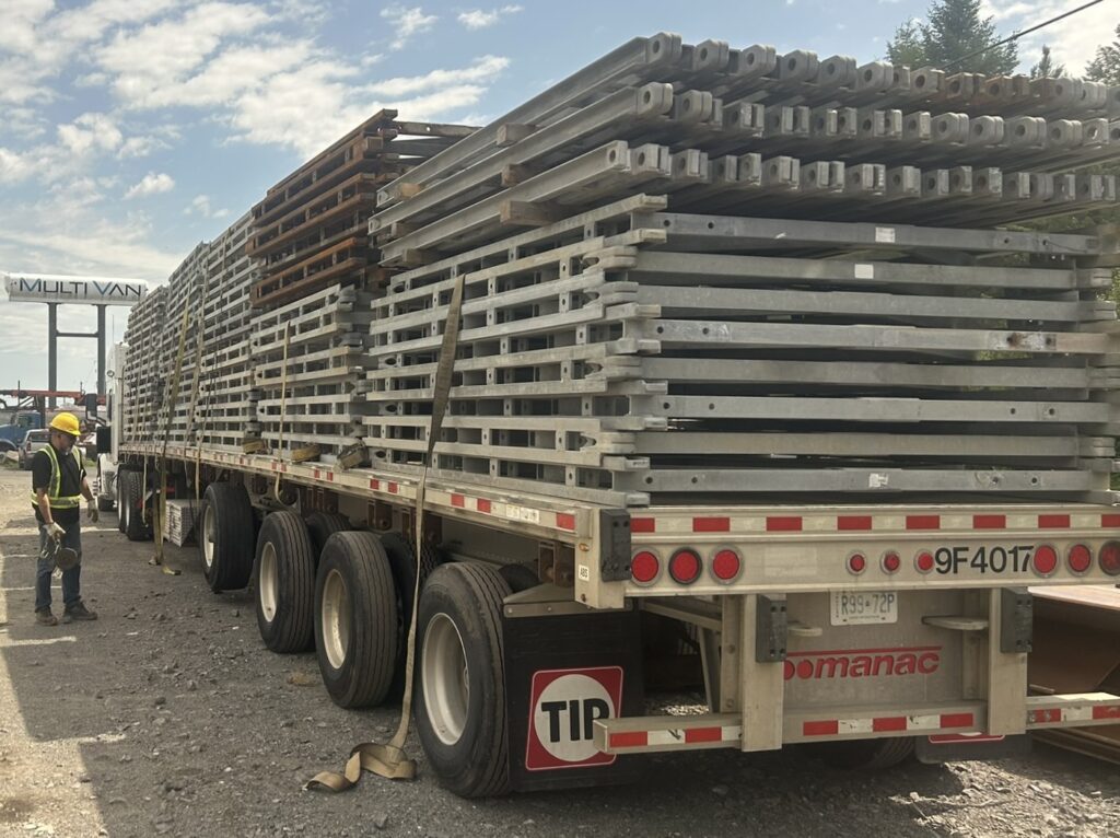 Bailey-Bridge-style detour bridge components on flatbed